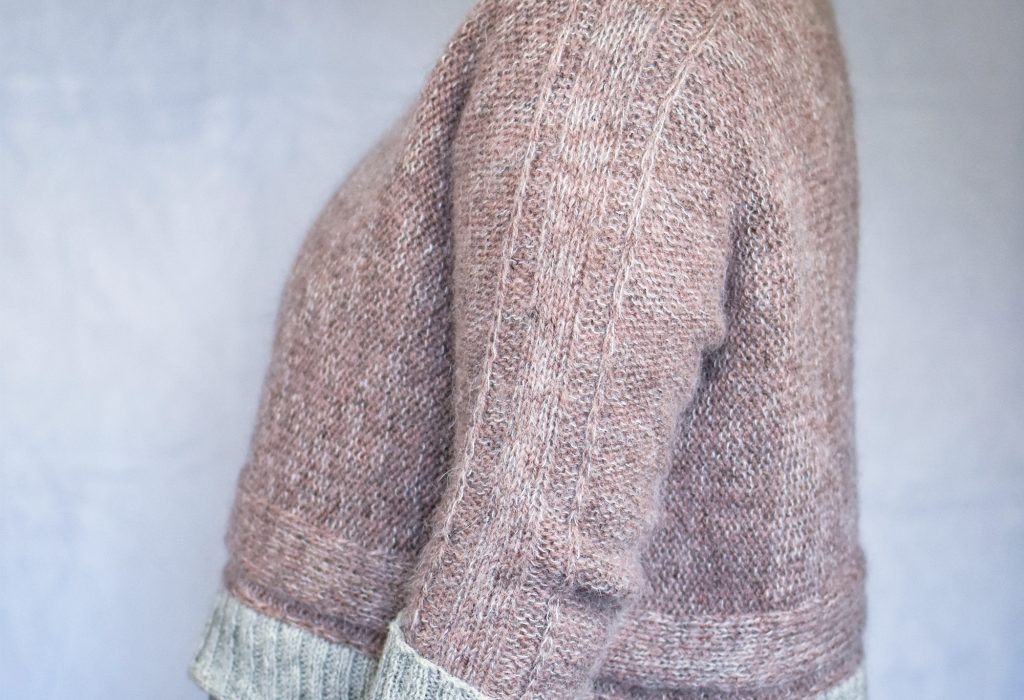Hazy Lanes cropped sweater knit sideways in dusty pink wool and mohair with silver gray ribbed cuffs and hem.