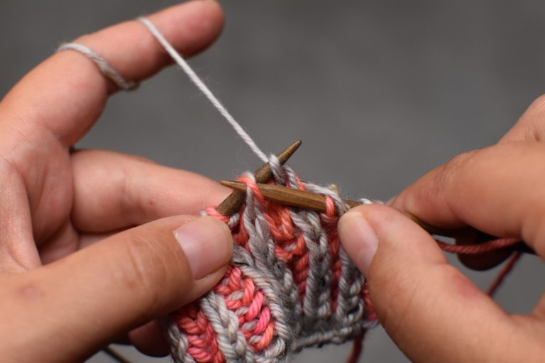 Step 5: Pass the next stitch (and its yarn-over) over and off the needle.