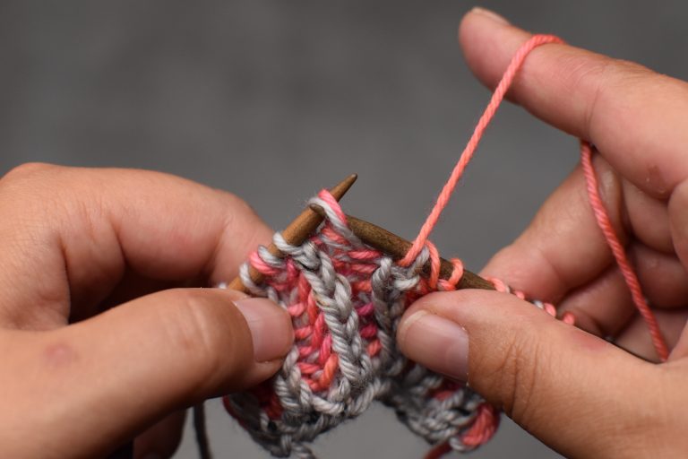 Step 1: With yarn in front, insert the needle from back to front through the stitch and its yarn-over.